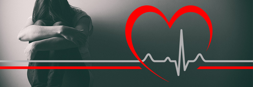 Eine junge Frau sitzt geknickt an einer Wand, im Vordergrund ist ein Herz und eine EKG-Grafik zu sehen