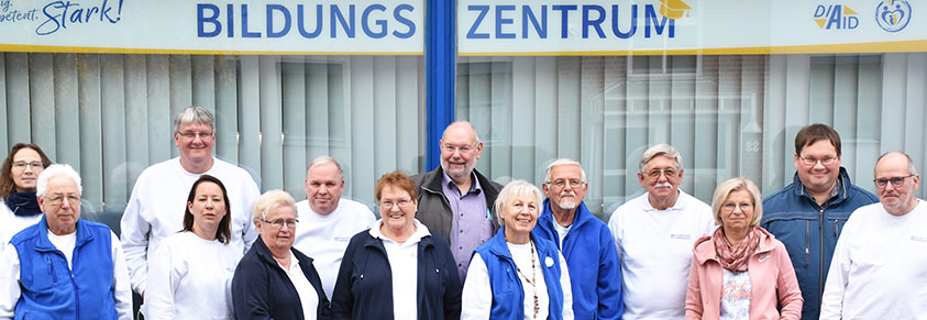 Ein Gruppenbild der Teilnehmenden vor dem Schaufenster des Bildungszentrums