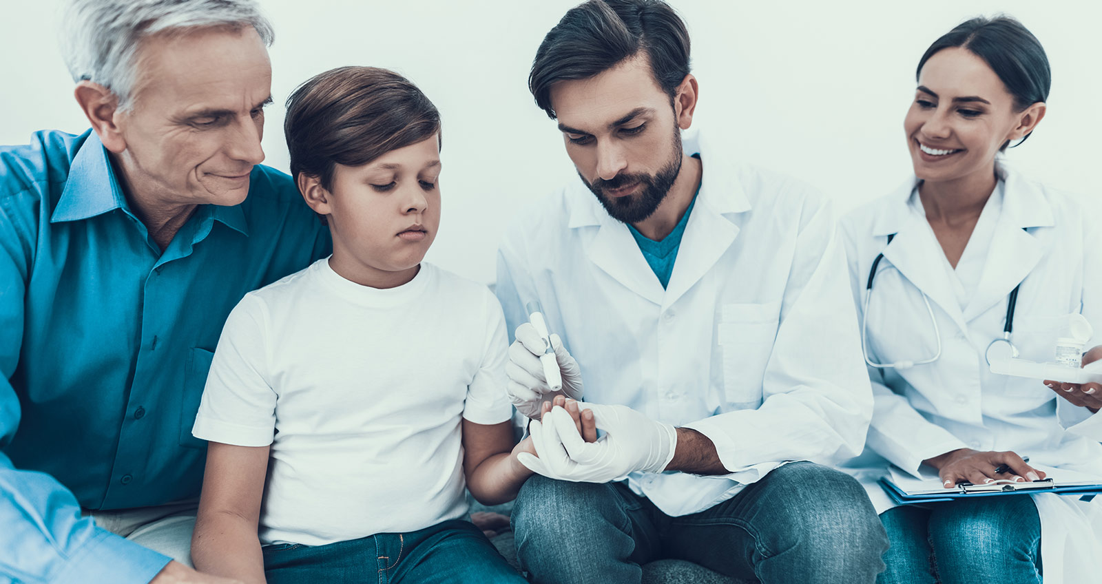 Mehrere Ärzte kümmern sich bei der Blutzuckermessung um ein Kind