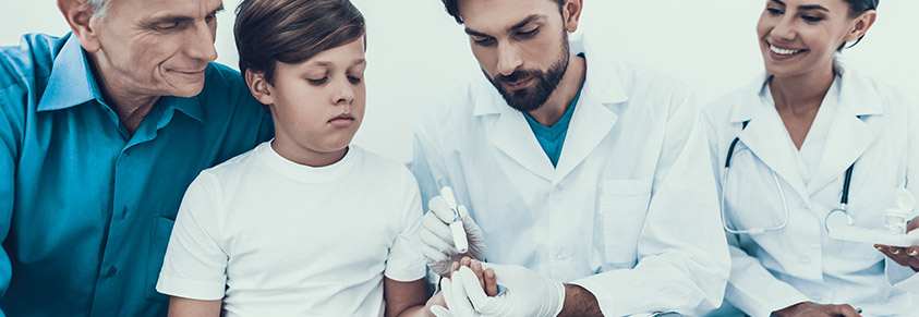 Mehrere Ärzte kümmern sich bei der Blutzuckermessung um ein Kind