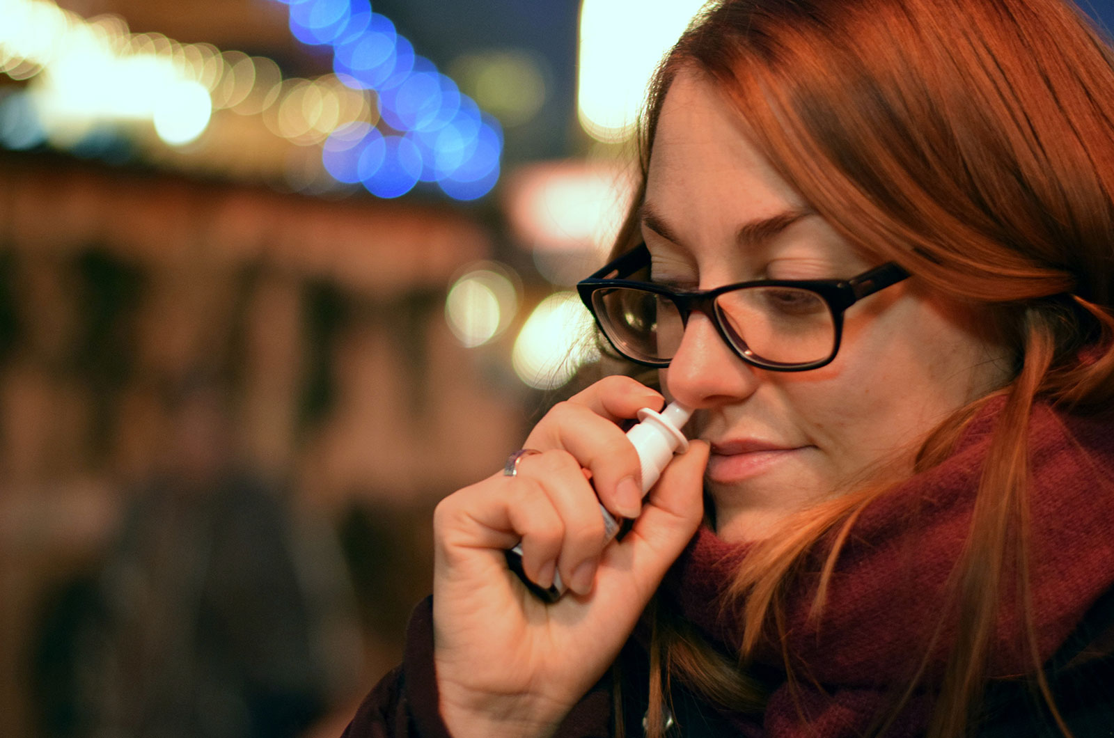 junge Frau nimmt ein Nasenspray