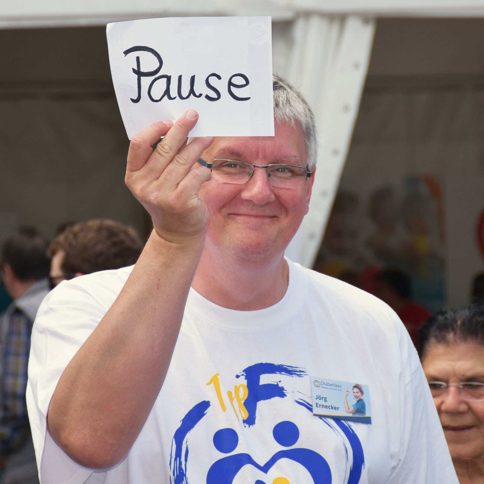 Ein Mann hält ein Schild mit der Aufschrift "Pause" hoch