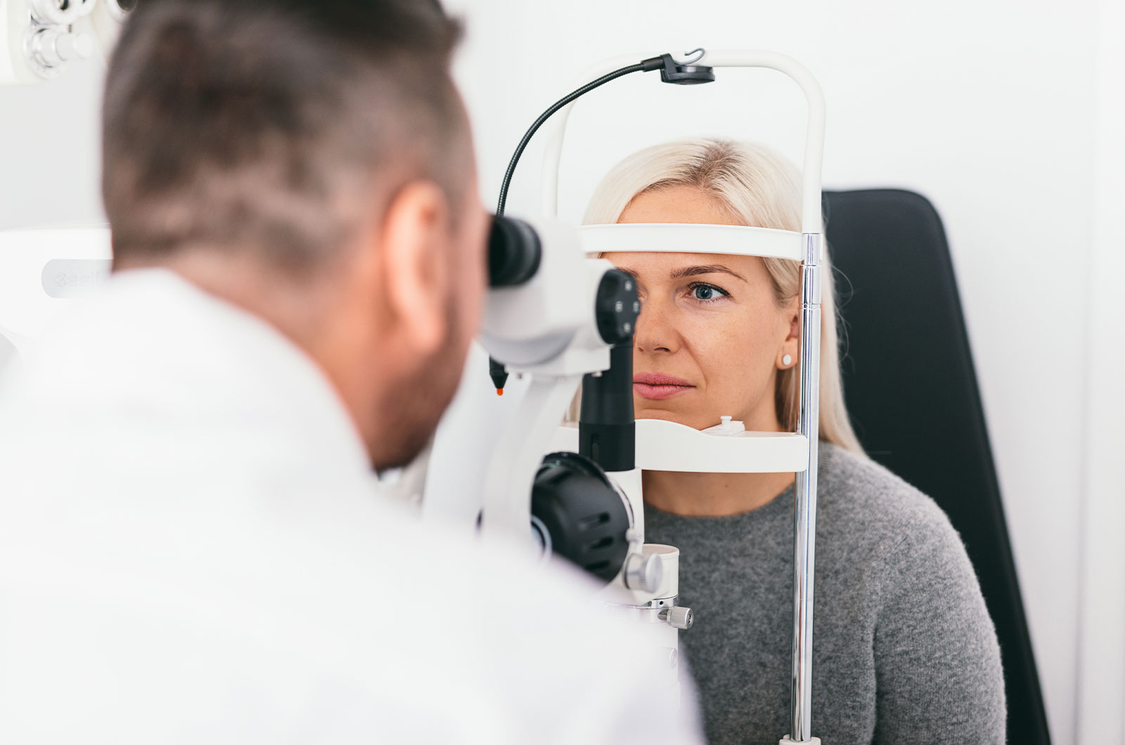 Frau, die sich im Behandlungszimmer des Arztes einer Sehprüfung unterzieht