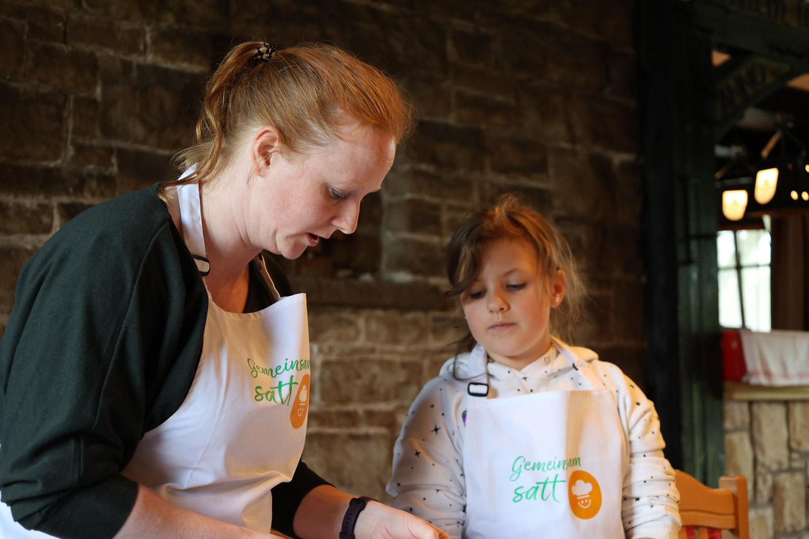 Corinna Dinse hilft einem Kind beim Kochen