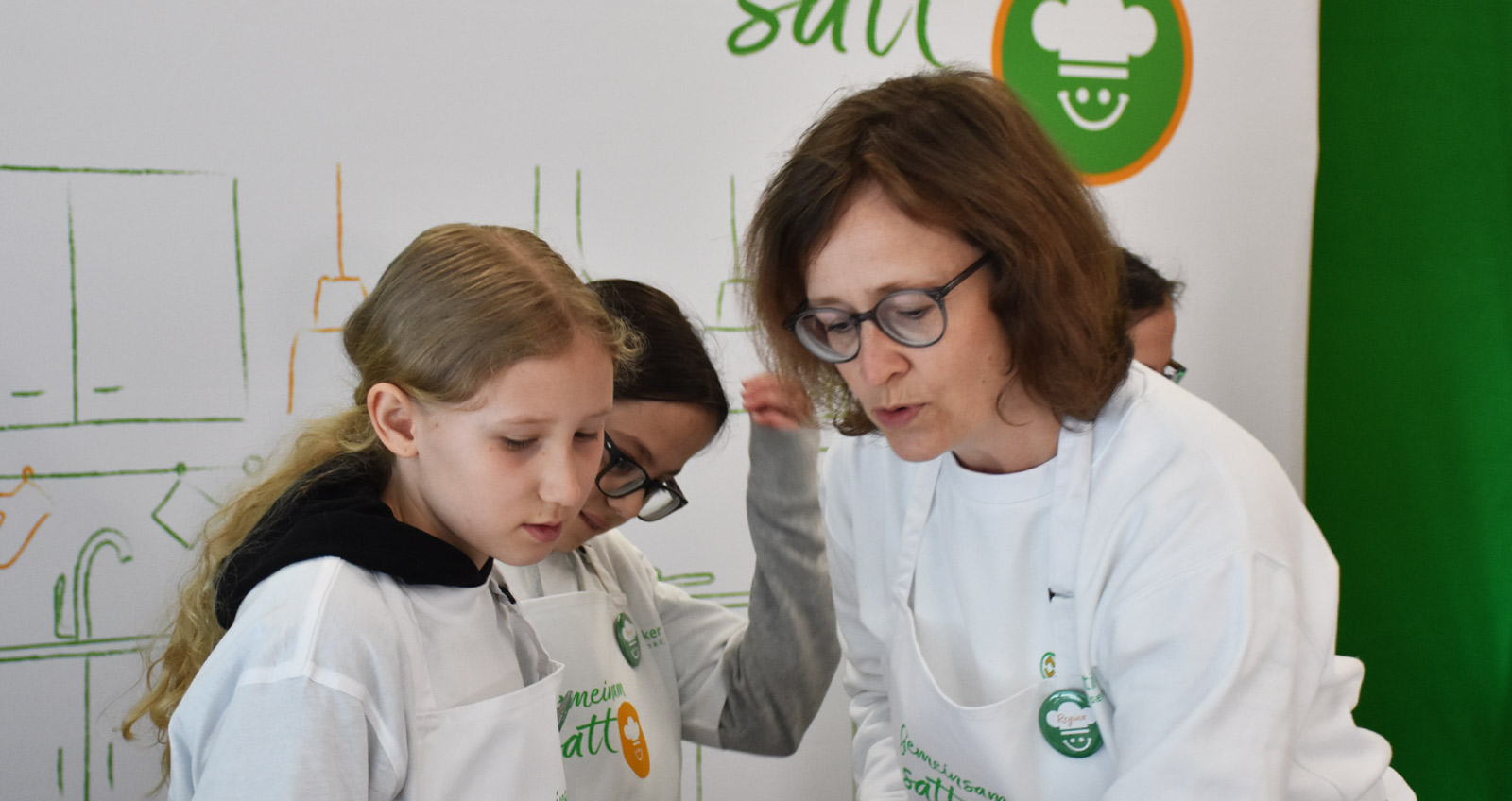 Regina Kröger hilft einem Kind beim Kochen
