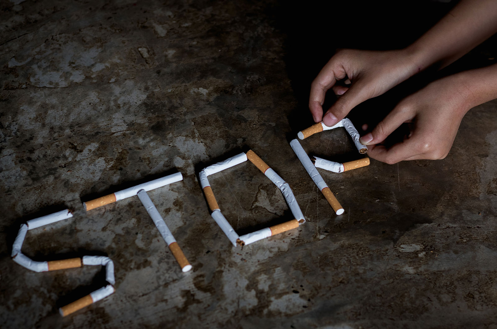 Schriftzug Stop mit Zigaretten gelegt, Für die Gesundheit, mit dem Zigarettenrauchen aufhören