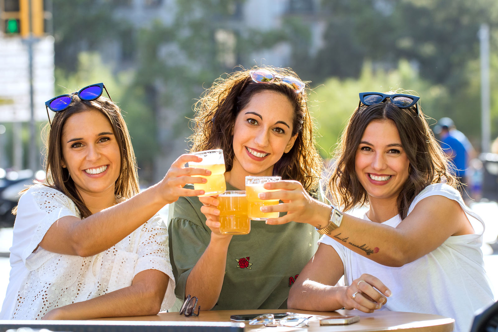 Drei junge Frauen prosten sich mit Bier zu.