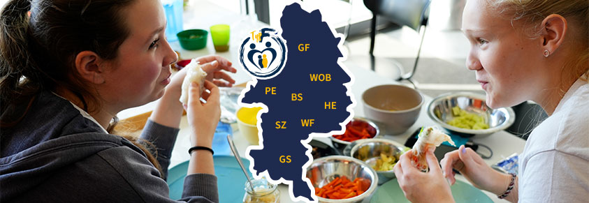 Zwei Mädchen unterhalten sich angeregt beim Essen von Sommerrollen