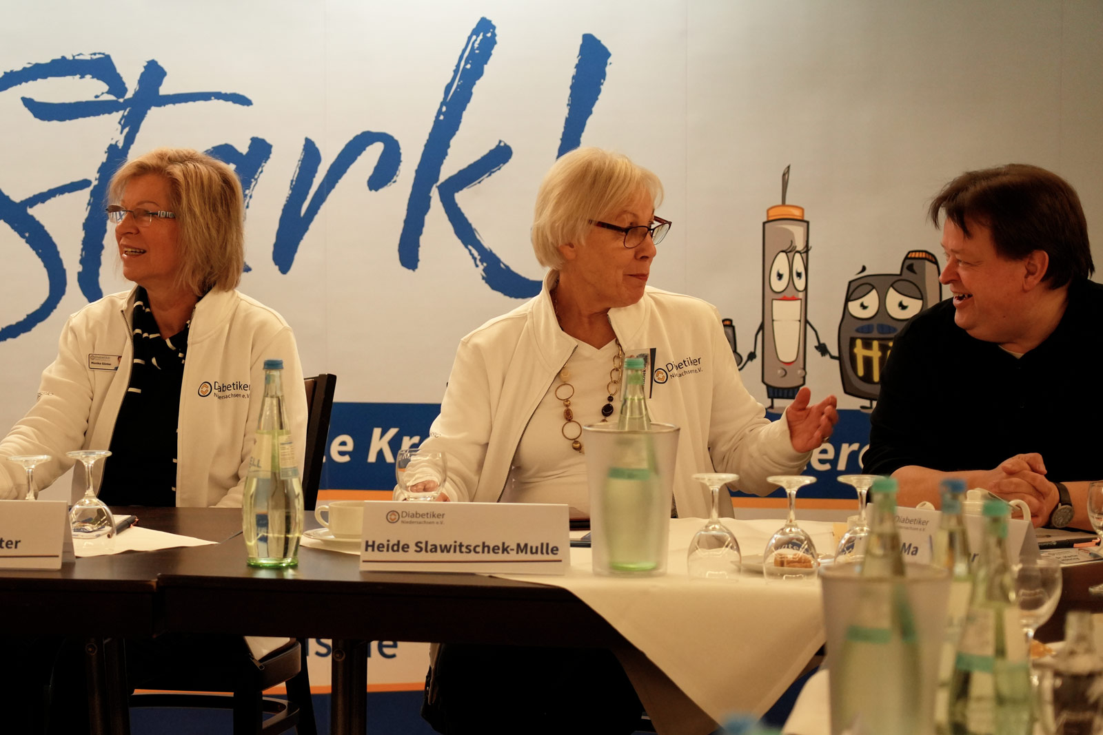 Gelöste Stimmung Drei Teilnehmende der Fortbildung unterhalten sich angeregt. Alle sind fröhlich dabei.
