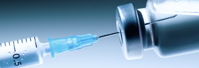 medizinische Spritze mit Nadel und einem Fläschchen mit Impfstoff