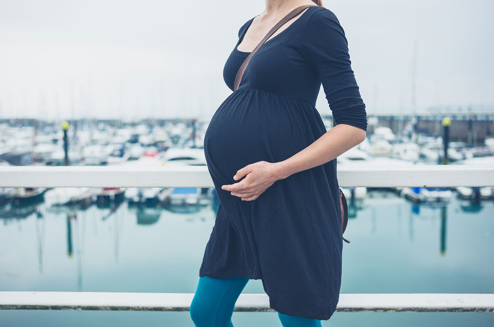 schwangere Frau beim Spazierengehen in einem Hafen