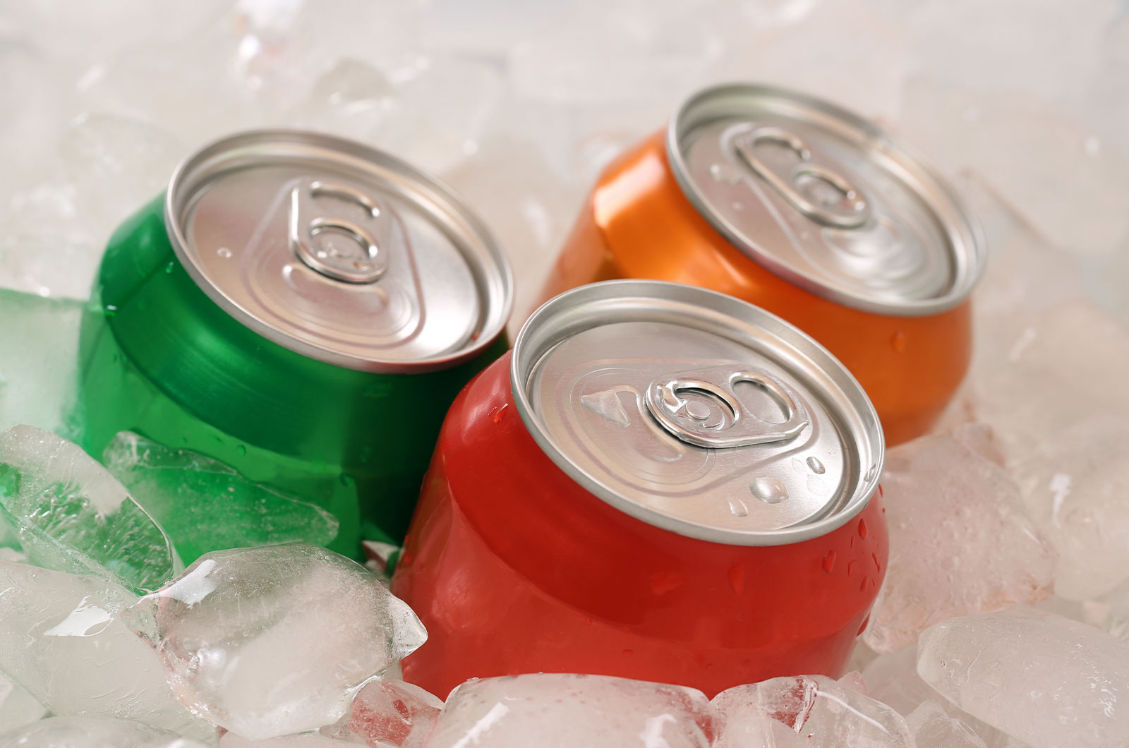 Cola und Limonade in Dosen auf Eis