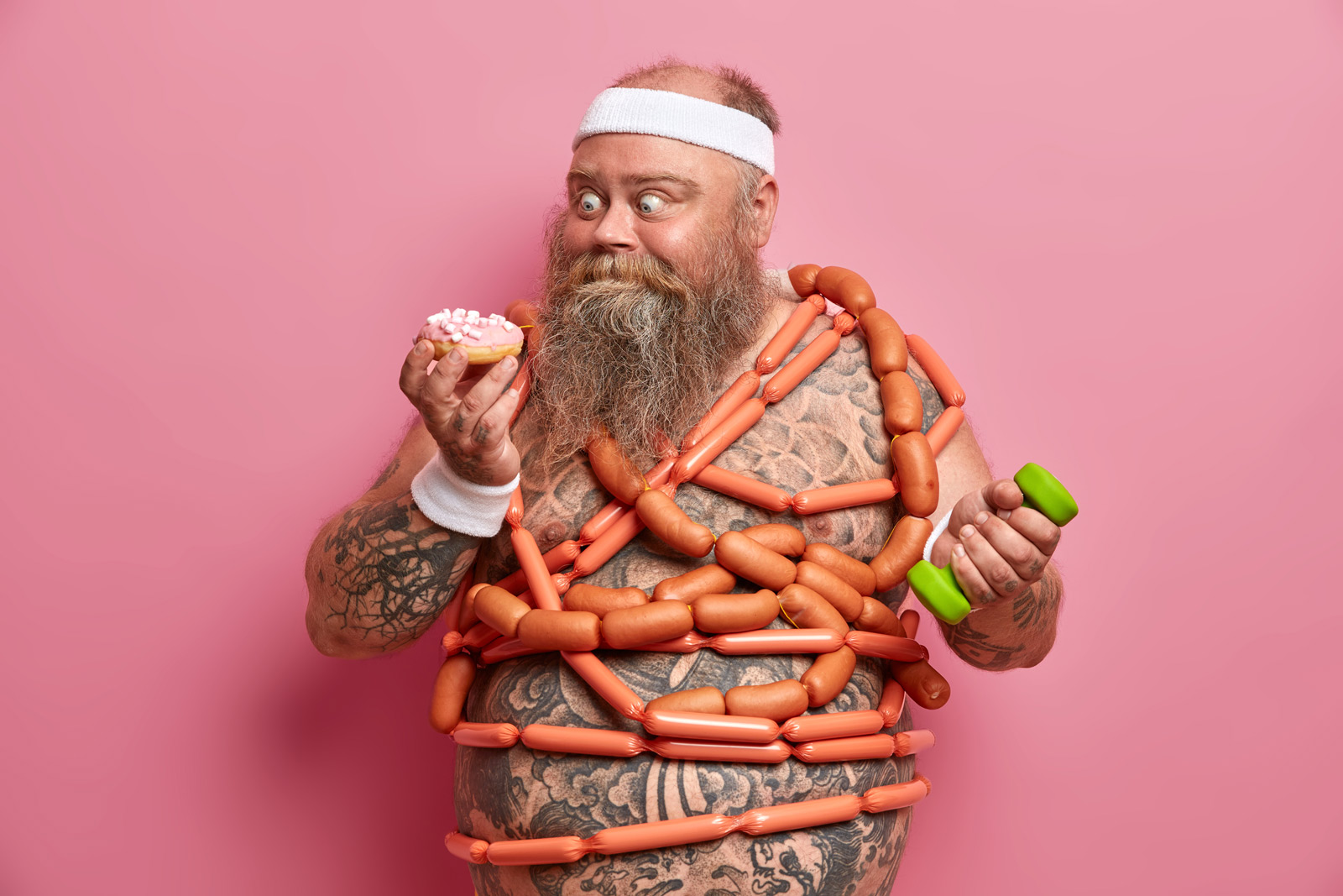 Ein korpulenter Mann mit einer Wurst-Kette um den Hals, in der linken Hand hält er eine Hantel, in der Rechten einen Donut mit rosa Glasur. Er schaut schmachtend auf den Donut.