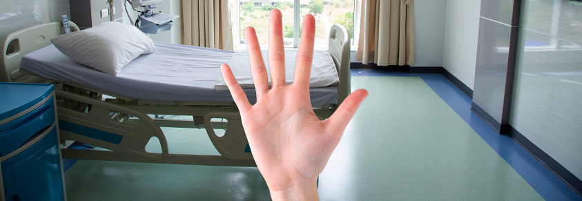 Eine Hand die 5 Finger hebt. Im Hintergrund ein Krankenhauszimmer