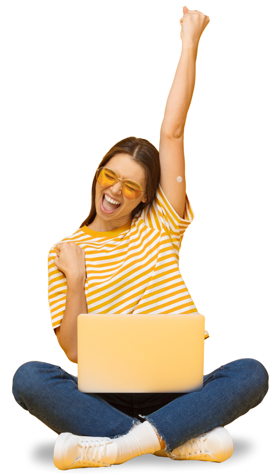 Eine junge Frau mit einem Sensor am Arm sitzt am Laptop und freut sich.