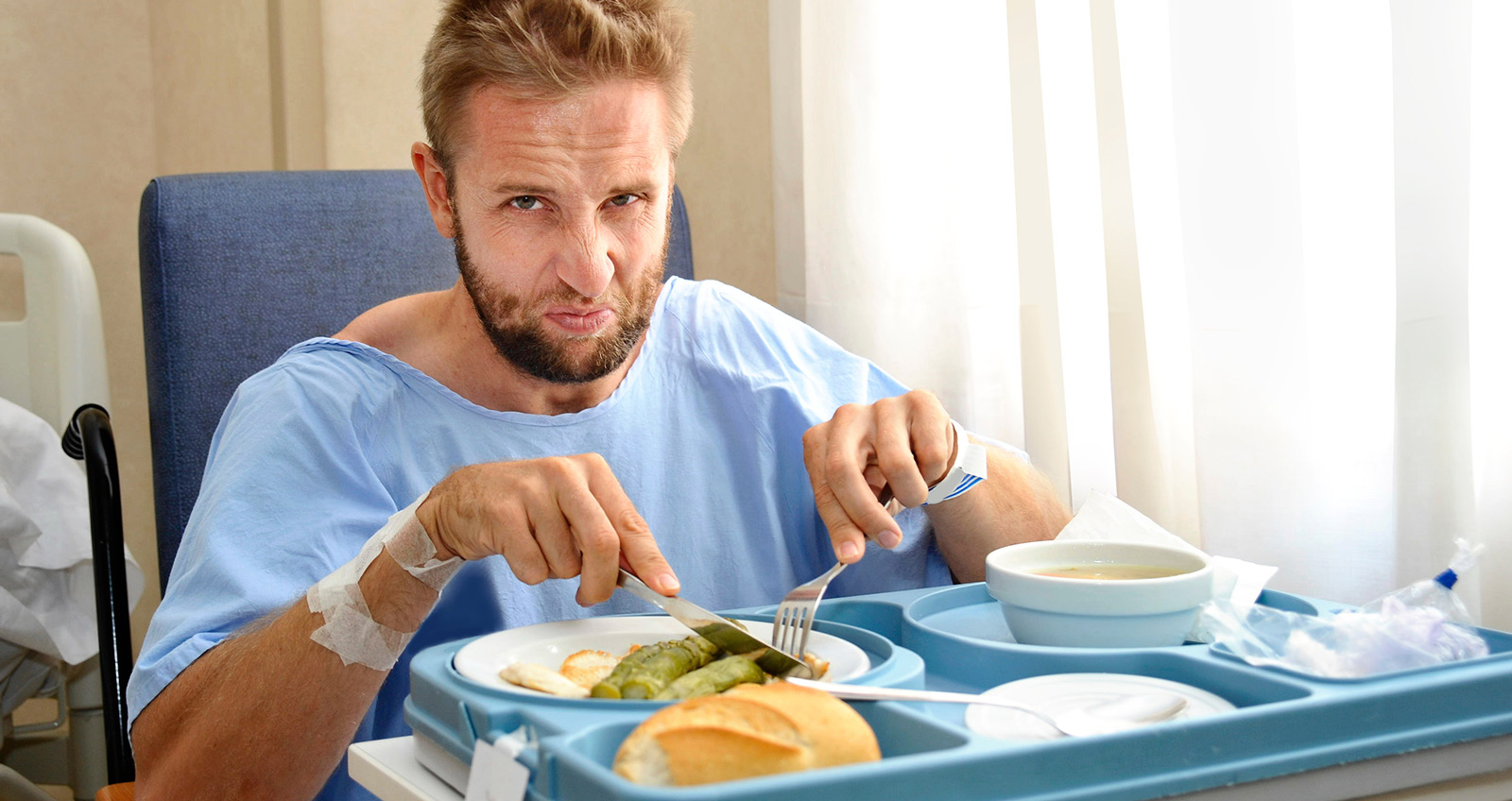 Ein Mann isst im Krankenhaus angewidert seine Mahlzeit