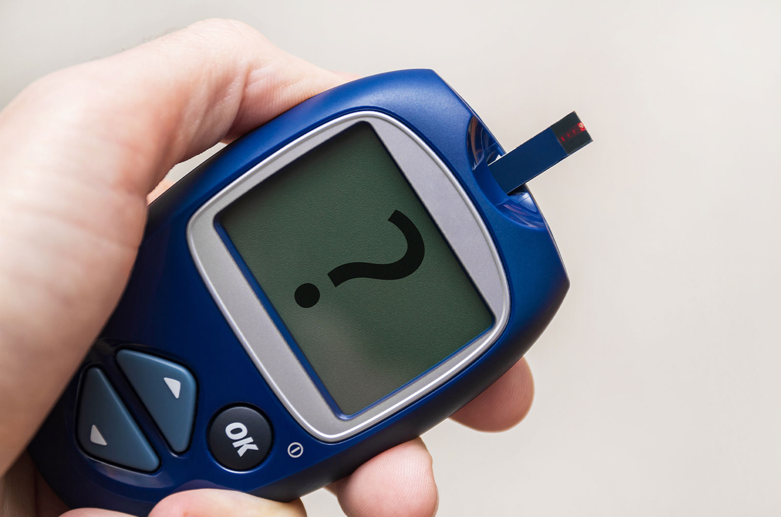 Blutzuckermessgerät Blutzuckermessgerät mit Teststreifen, Fragezeichen auf dem Display