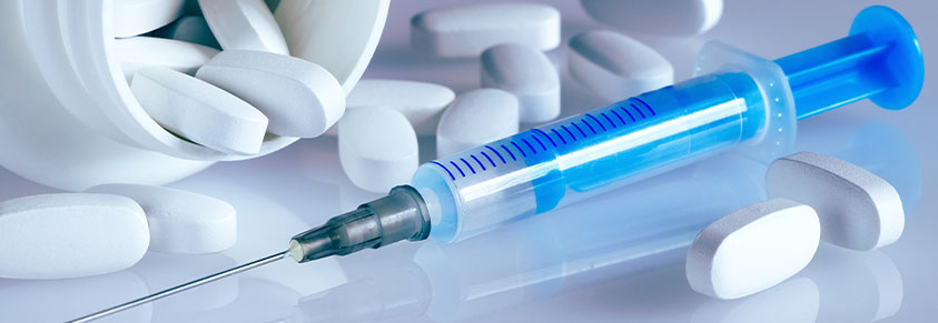 weißes Tablettenröhrchen, Medikament gegen Blutchochdruck und Insulinspritze auf hellblauem Hintergrund