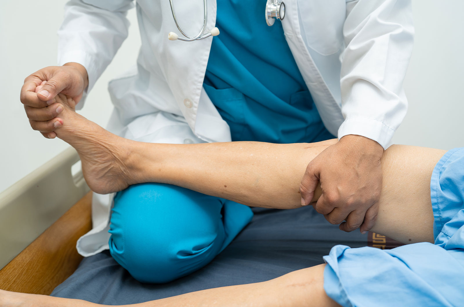Arzt, Physiotherapeut untersucht, behandelt Bein eines  Patienten