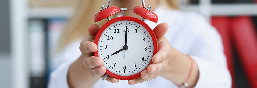 junges Mädchen mit einem roten Wecker in der Hand, mit Uhrzeit 8:00 Uhr früh oder 20:00 Uhr abends