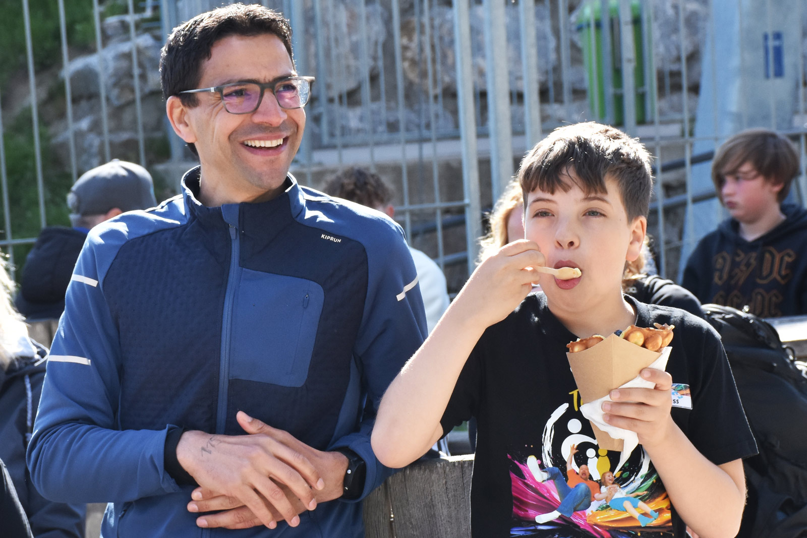 Schlemmerei EIn Junge isst neben seinem Vater eine Waffel mit Eis,