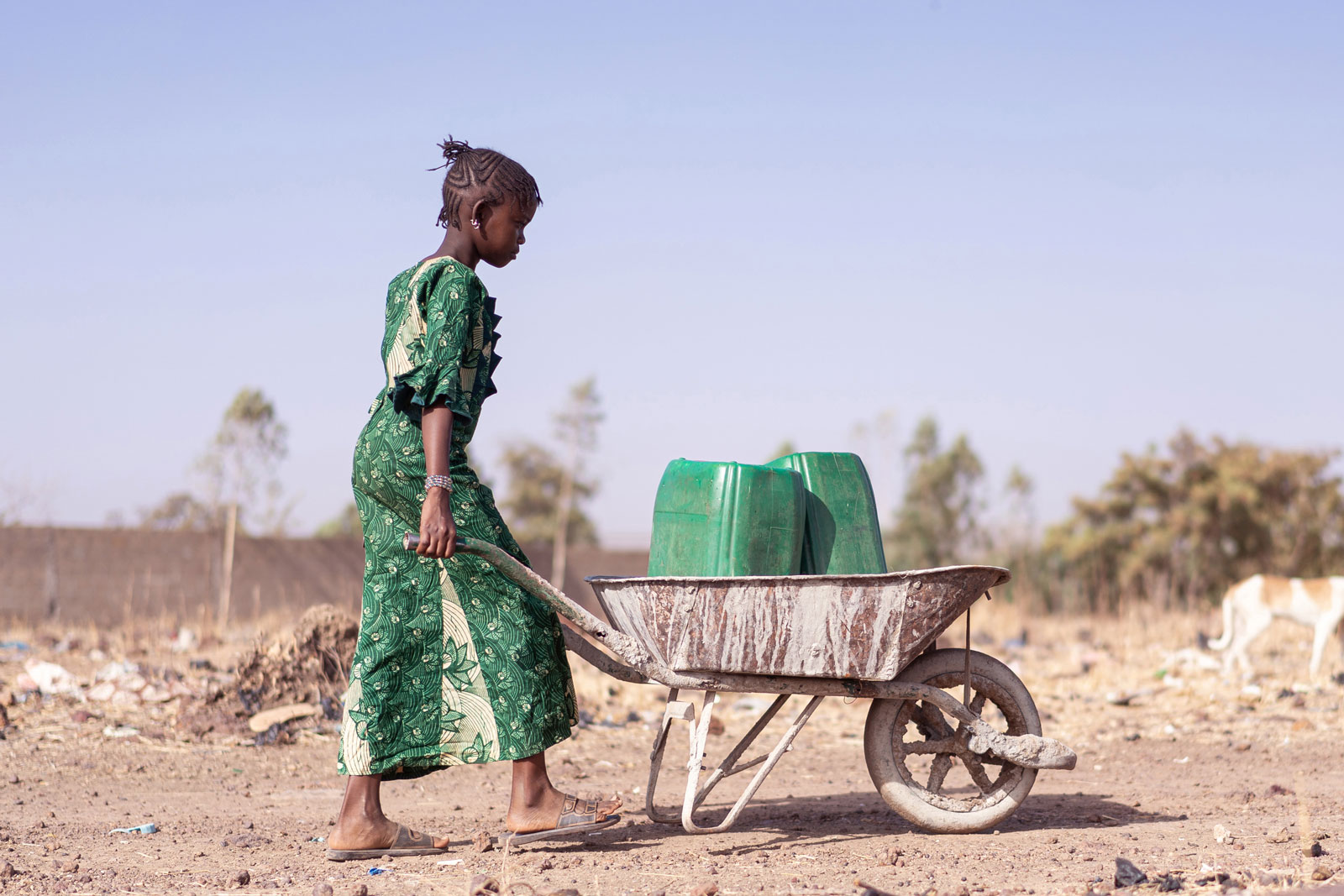 Entsorgung Eine Frau in Afrika entsprgt Müllkanister