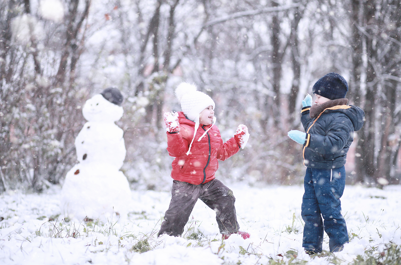 spielende Kinder im Schnee, mit gebauten Schneemann