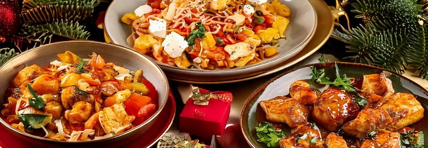 3 Teller mit asiatischen Gerichten auf einem weihnachtlich geschmückten Tisch