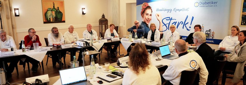 Eine große Gruppe Slebsthilfegruppenleiter auf einer Sitzung