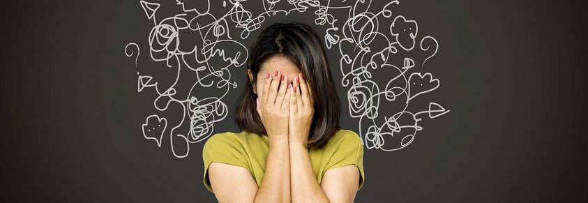 Eine Frau legt verzweifelt ihr Gesicht in ihre Hände