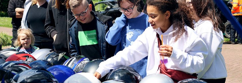 Kinder suchen Helme für das Quadfahren aus.