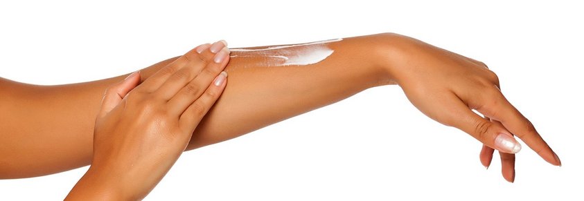 Eine Frau cremt ihren Arm ein